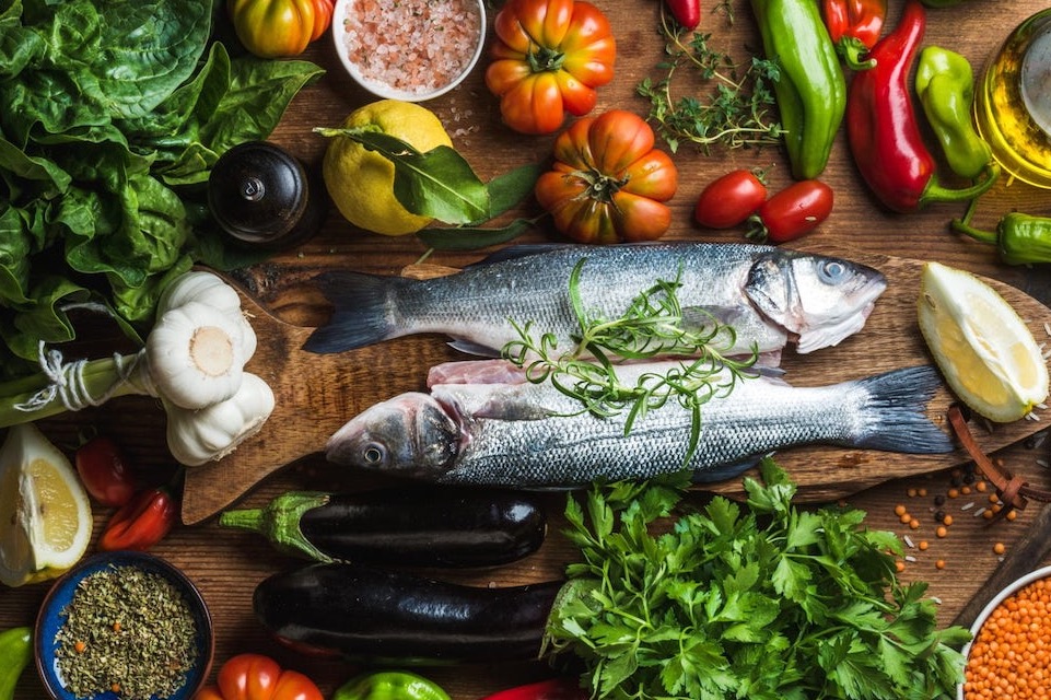 Poisson frais entouré de légumes et d’herbes